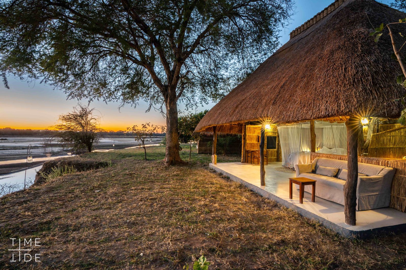 Exterior of a chalet with views over the river and private terrace at luxury safari camp Kakuli Bush Camp in Zambia's South Luangwa National Park