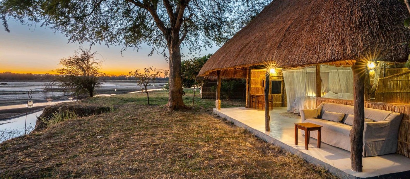 Exterior of a chalet with views over the river and private terrace at luxury safari camp Kakuli Bush Camp in Zambia's South Luangwa National Park