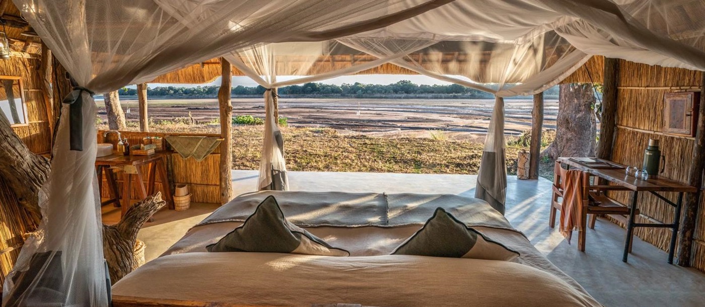 View from a chalet with ensuite bathroom and private terrace over the dried river bed at luxury safari camp Kakuli Bush Camp in Zambia's South Luangwa National Park