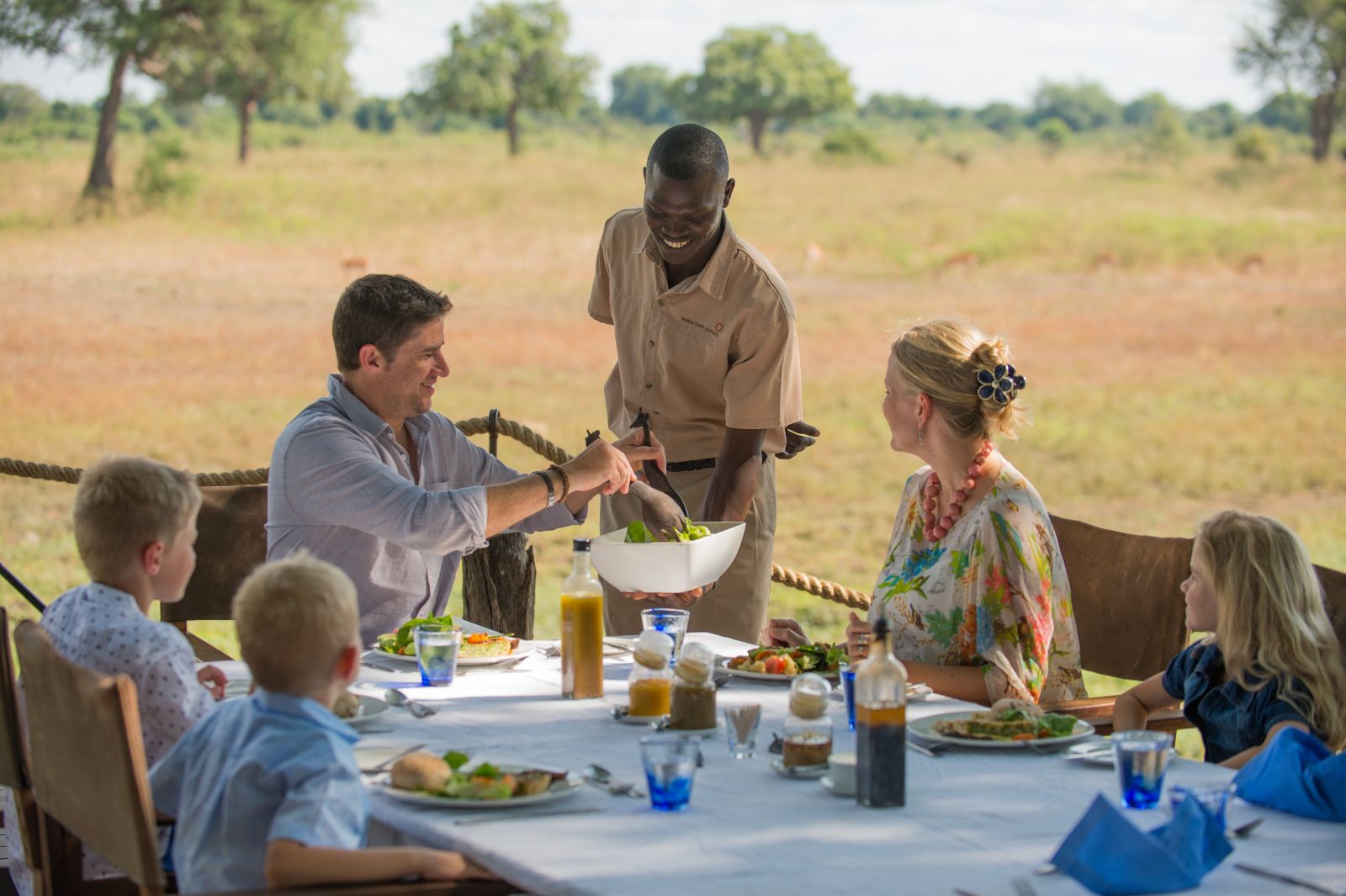 Family enjoying outdoor dining at the Luangwa Safari House in Zambia