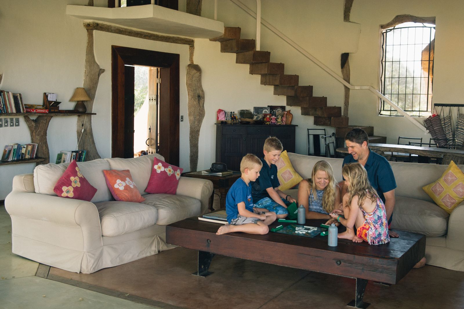 Family playing a game together in the living area of the Luangwa Safari House in Zambia