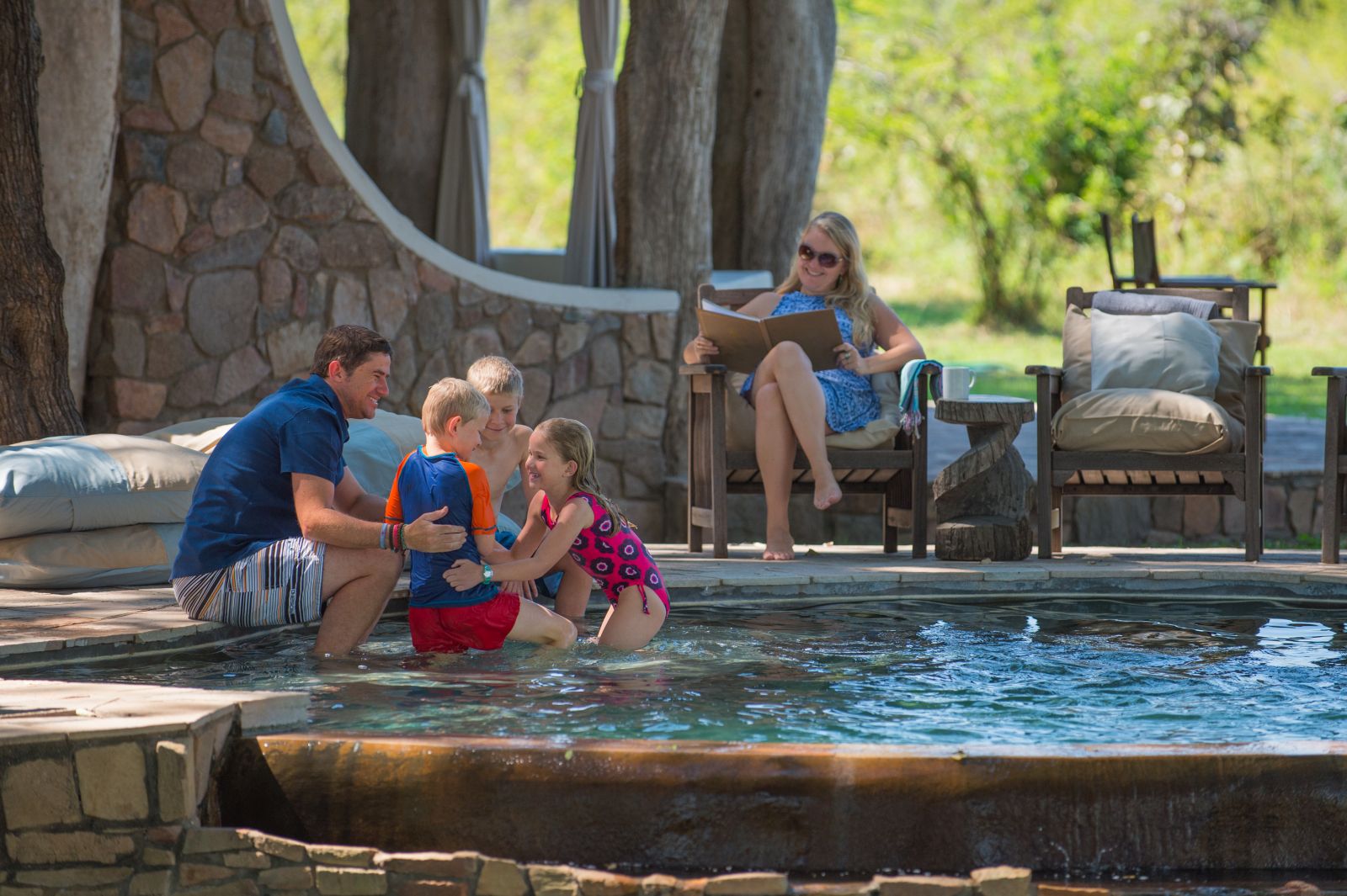 Family enjoying the swimming pool at the Luangwa Safari House in Zambia