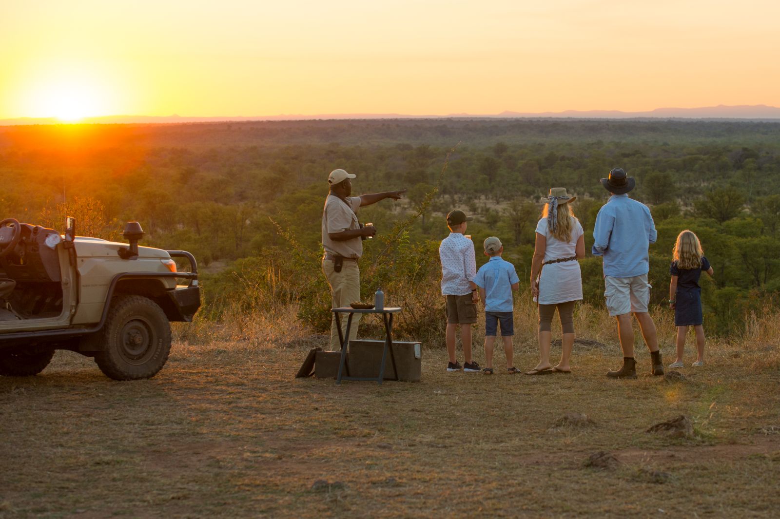 Family enjoying the views over sundowners from the Luangwa Safari House in Zambia