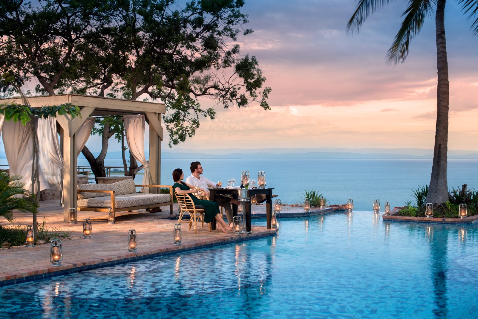 Couple enjoying the view over Lake Kariba by the infinity pool at luxury safari lodge Bumi Hills in Zimbabwe