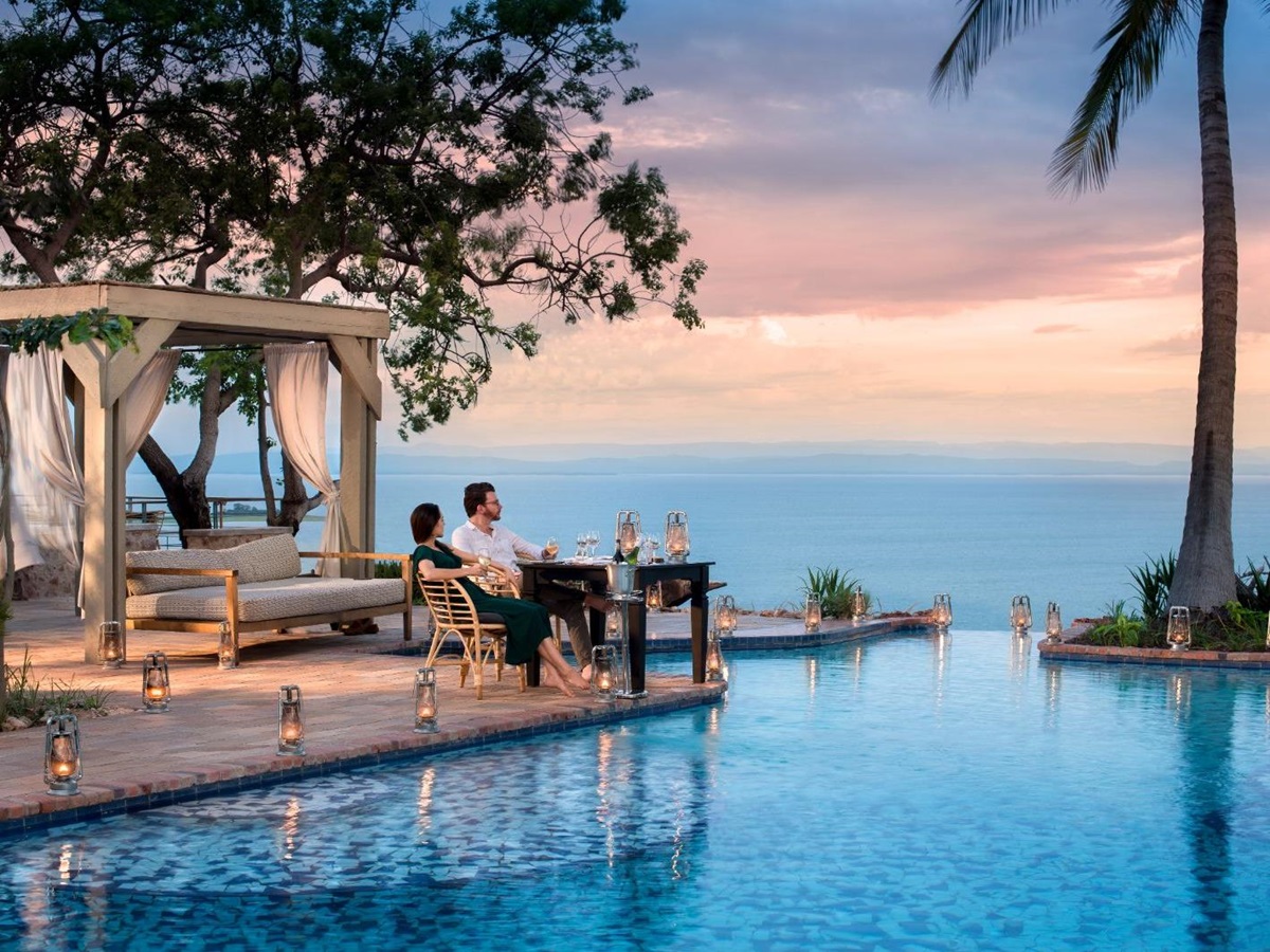 Couple enjoying the view over Lake Kariba by the infinity pool at luxury safari lodge Bumi Hills in Zimbabwe