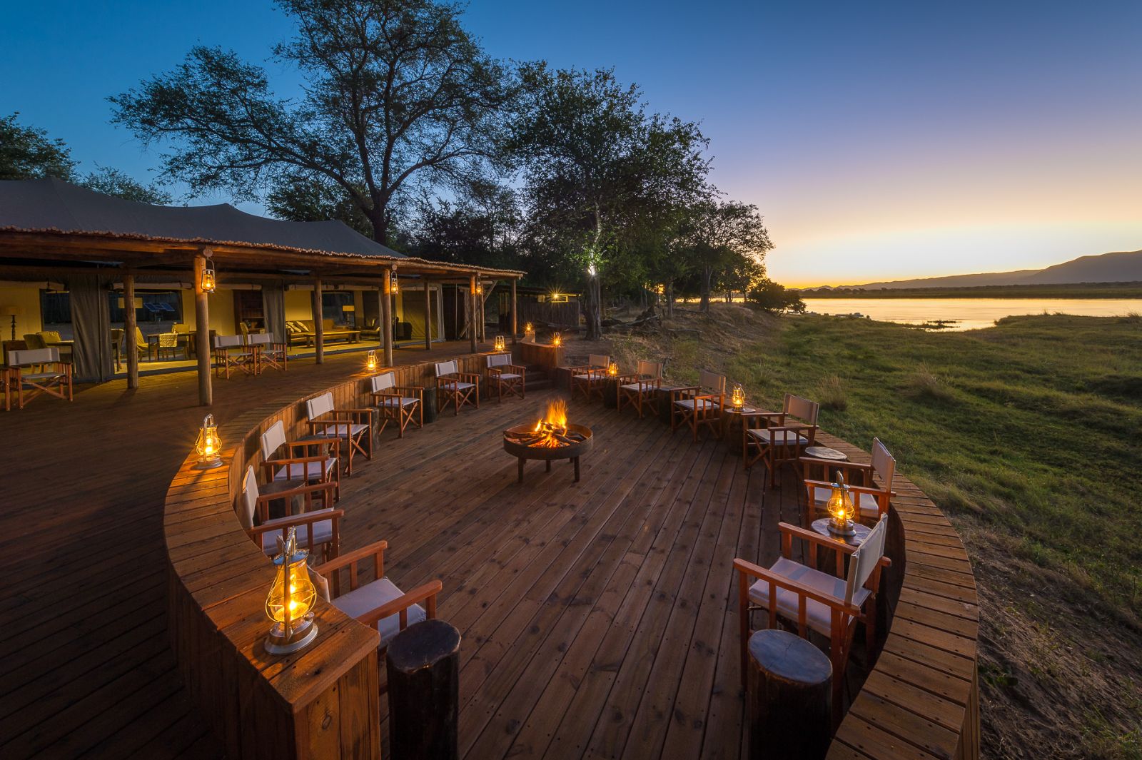 Campfire on outdoor decking area at luxury camp Ruckomechi