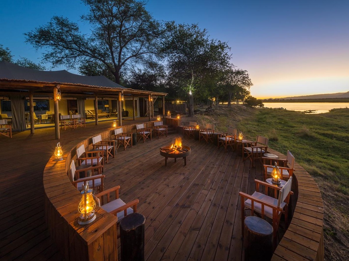 Campfire on outdoor decking area at luxury camp Ruckomechi