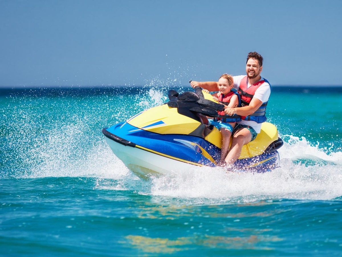 Father and sun jetskiing in turquoise waters