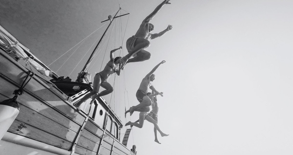 People jumping nto the sea from the side of a boat