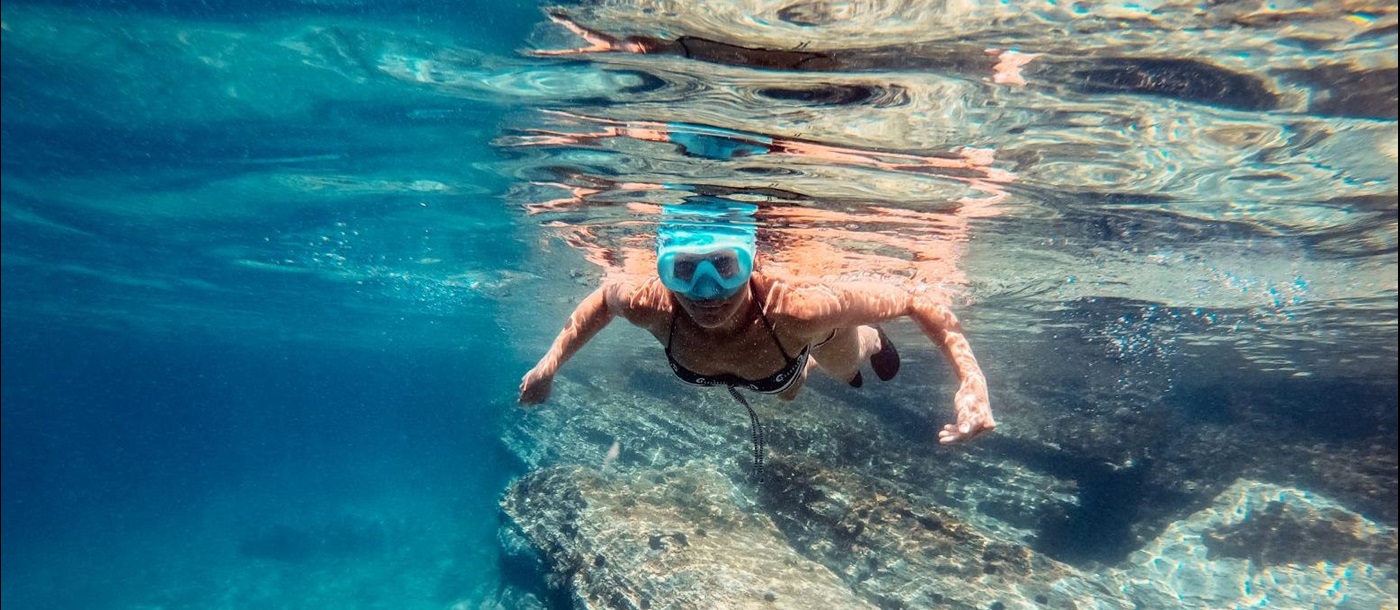 Young woman snorkelling in turquoise blue waters
