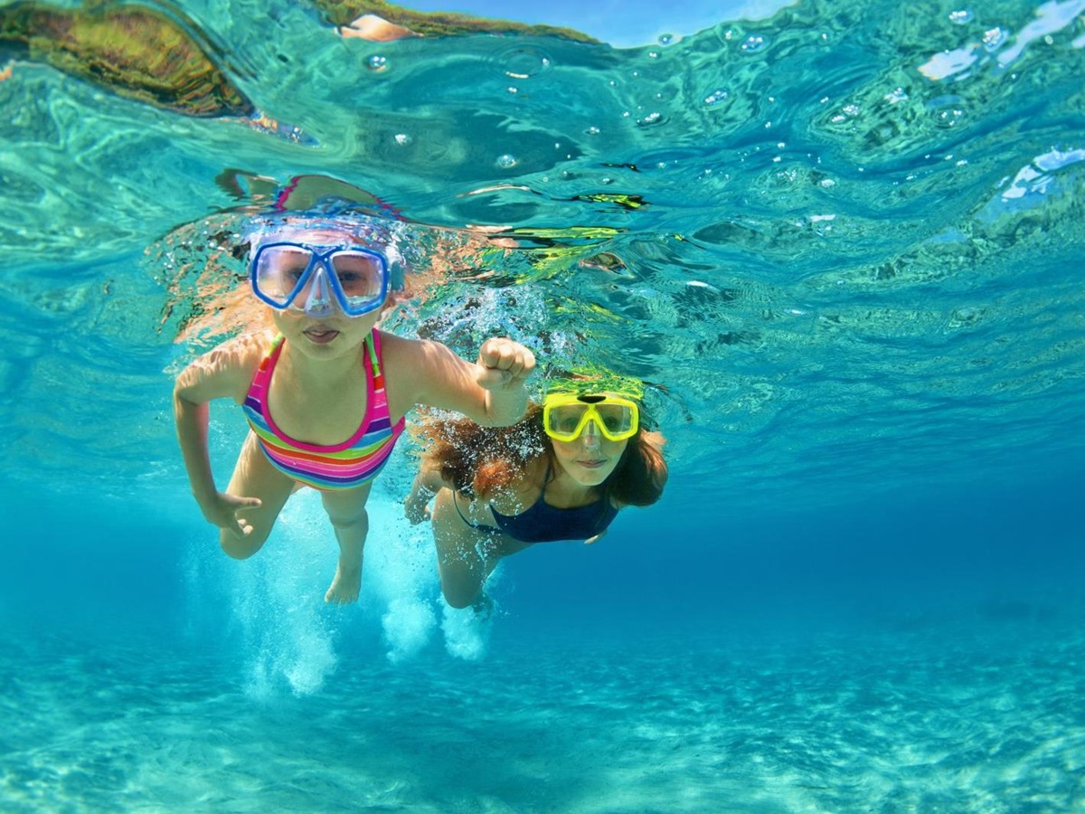 Mother and child snorkelling in crystal-clear waters