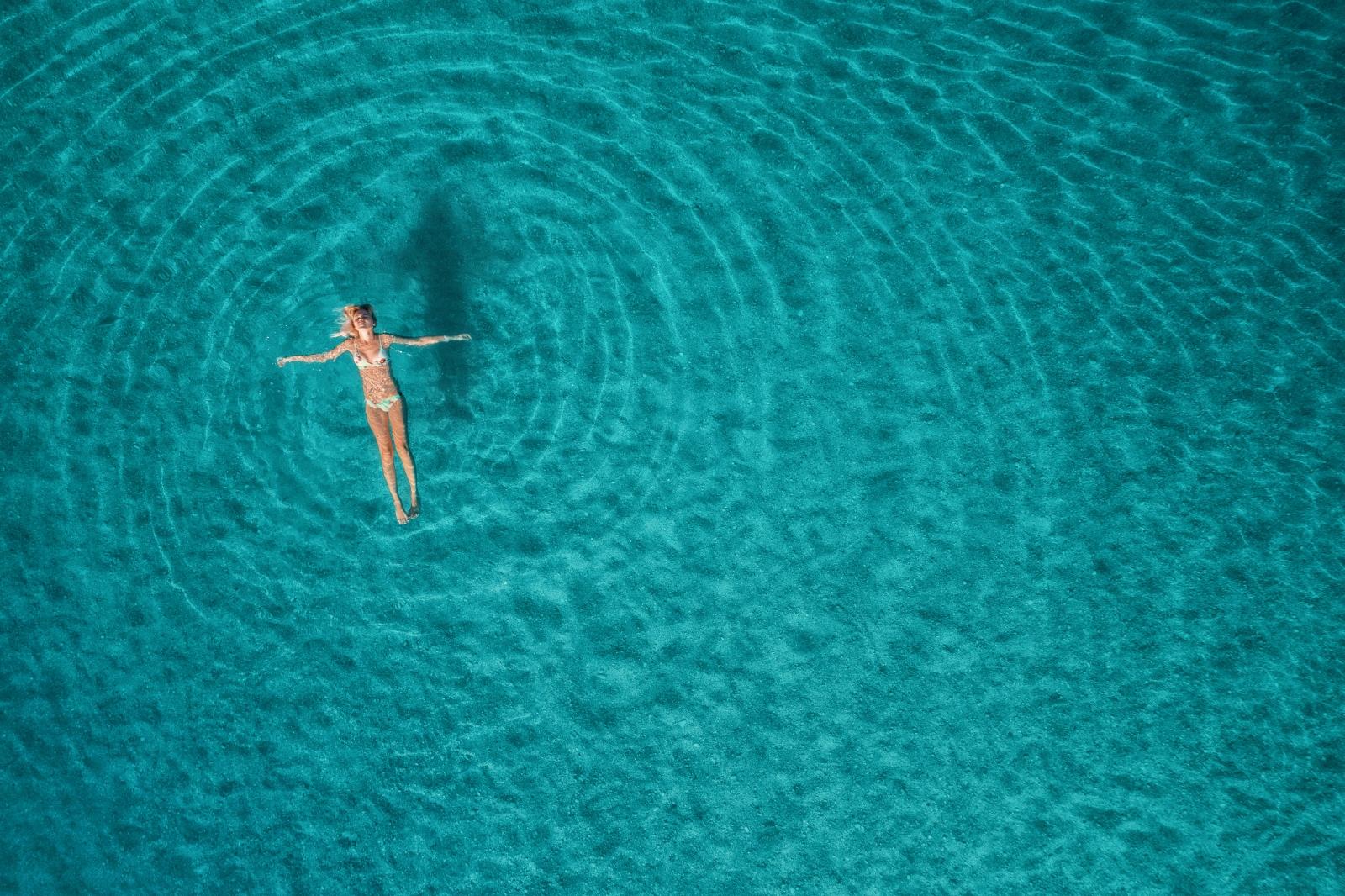 Woman floating in clear turquoise water