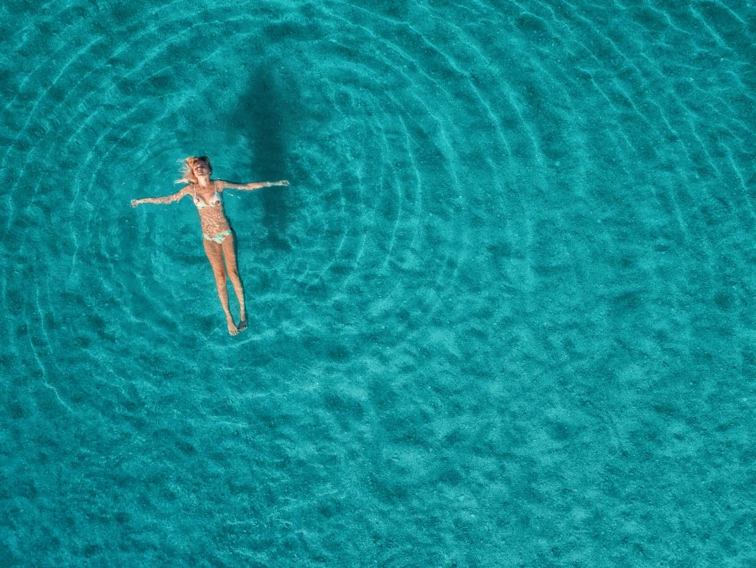 Woman floating in clear turquoise water