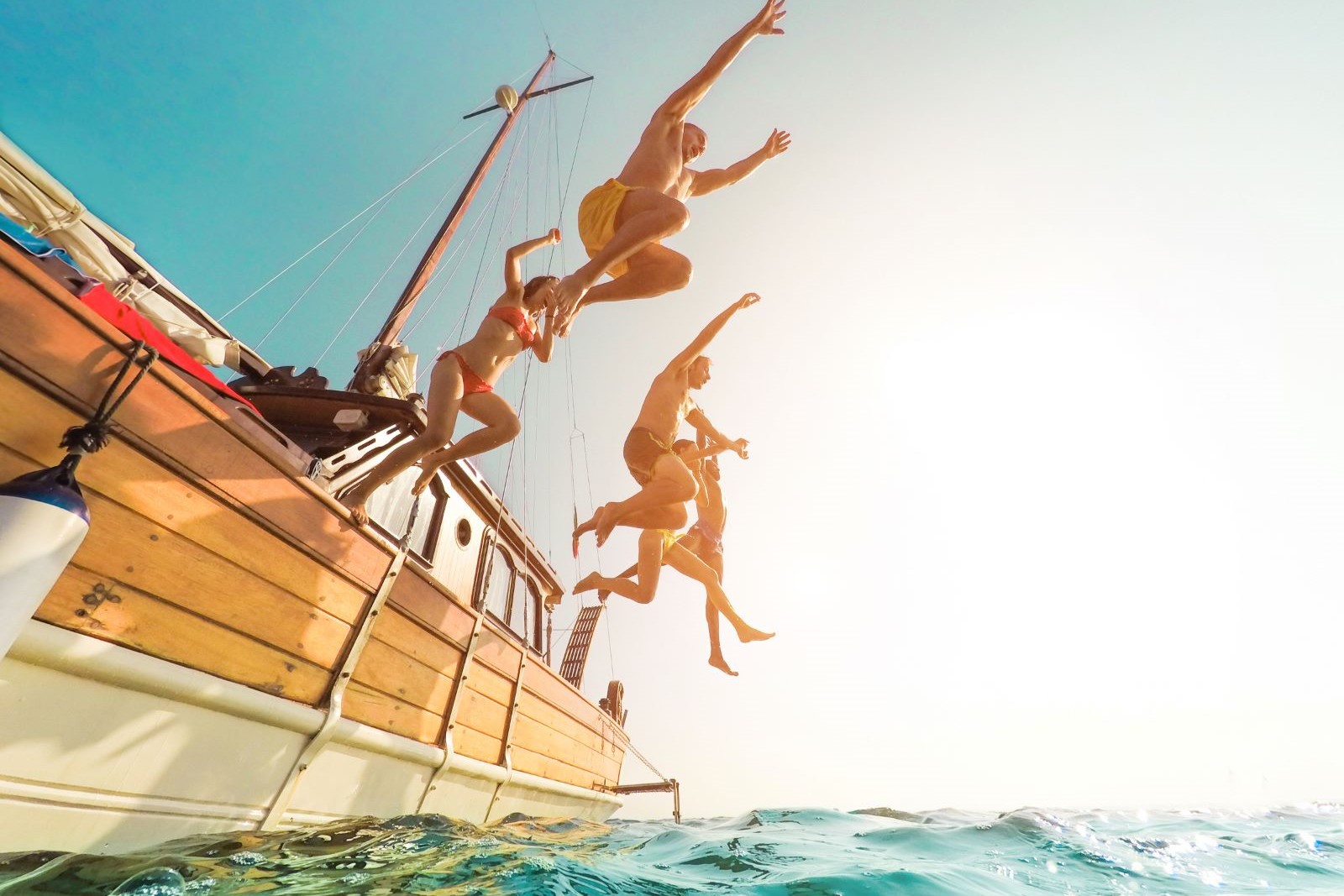 A family jumping from the side of a boat while on vacation