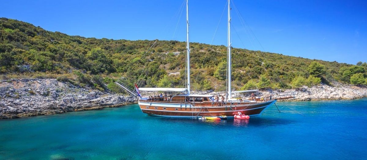 The Allure gulet moored in a calm bay of turquouse waters in Croatia