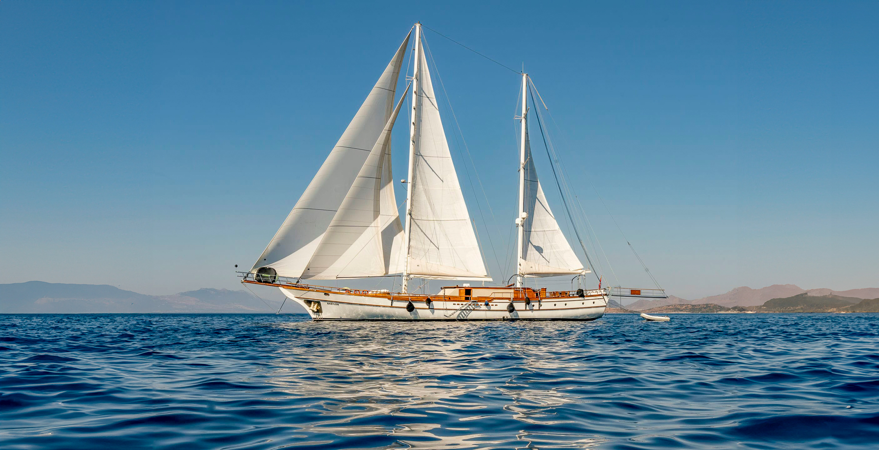 Exterior view of the Babylon luxury gulet with sails up in Turkey