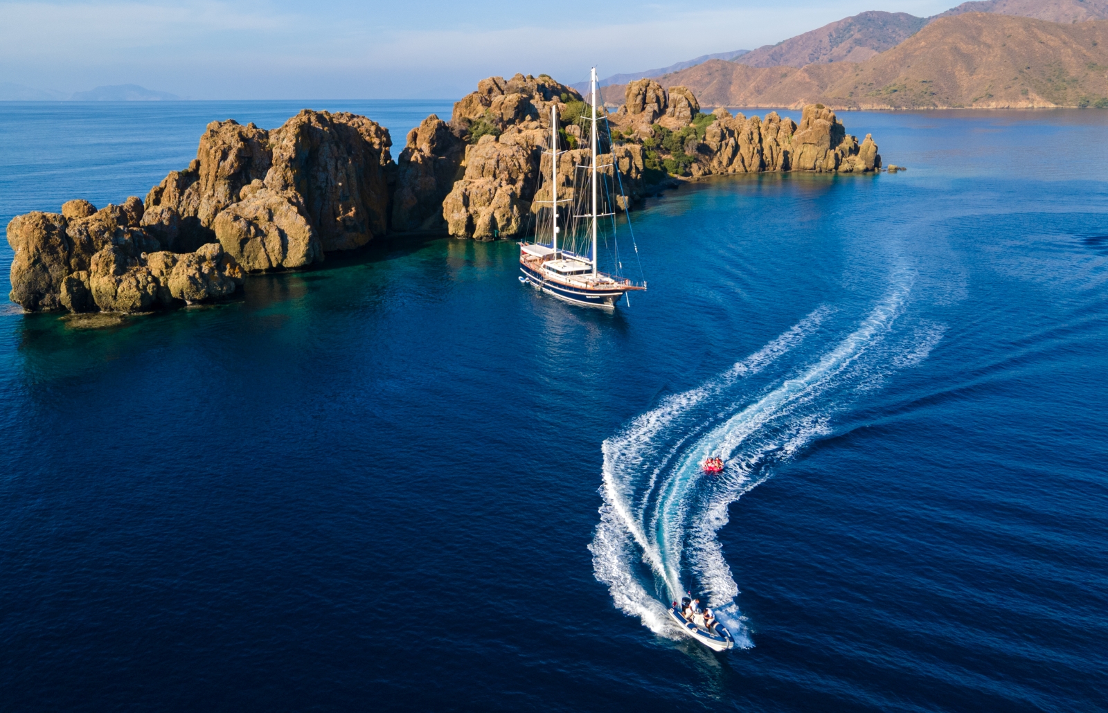 Aerial shot of luxury gulet Blue Heaven anchored off the Turkish coast with a speedboat