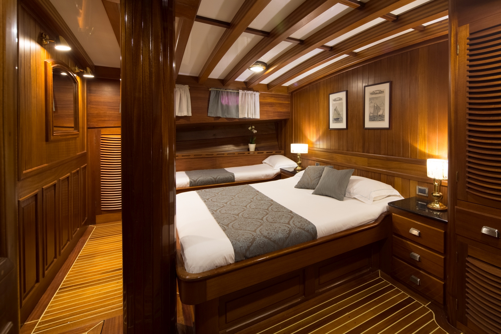 Family cabin with double bed and single bed, storage and wooden decor onboard the luxury gulet Carpe Diem 7
