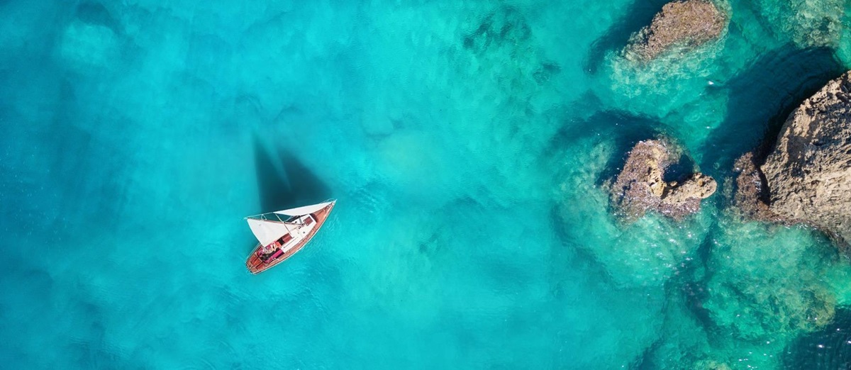 Aerial view of a yacht sailing through turquoise waters
