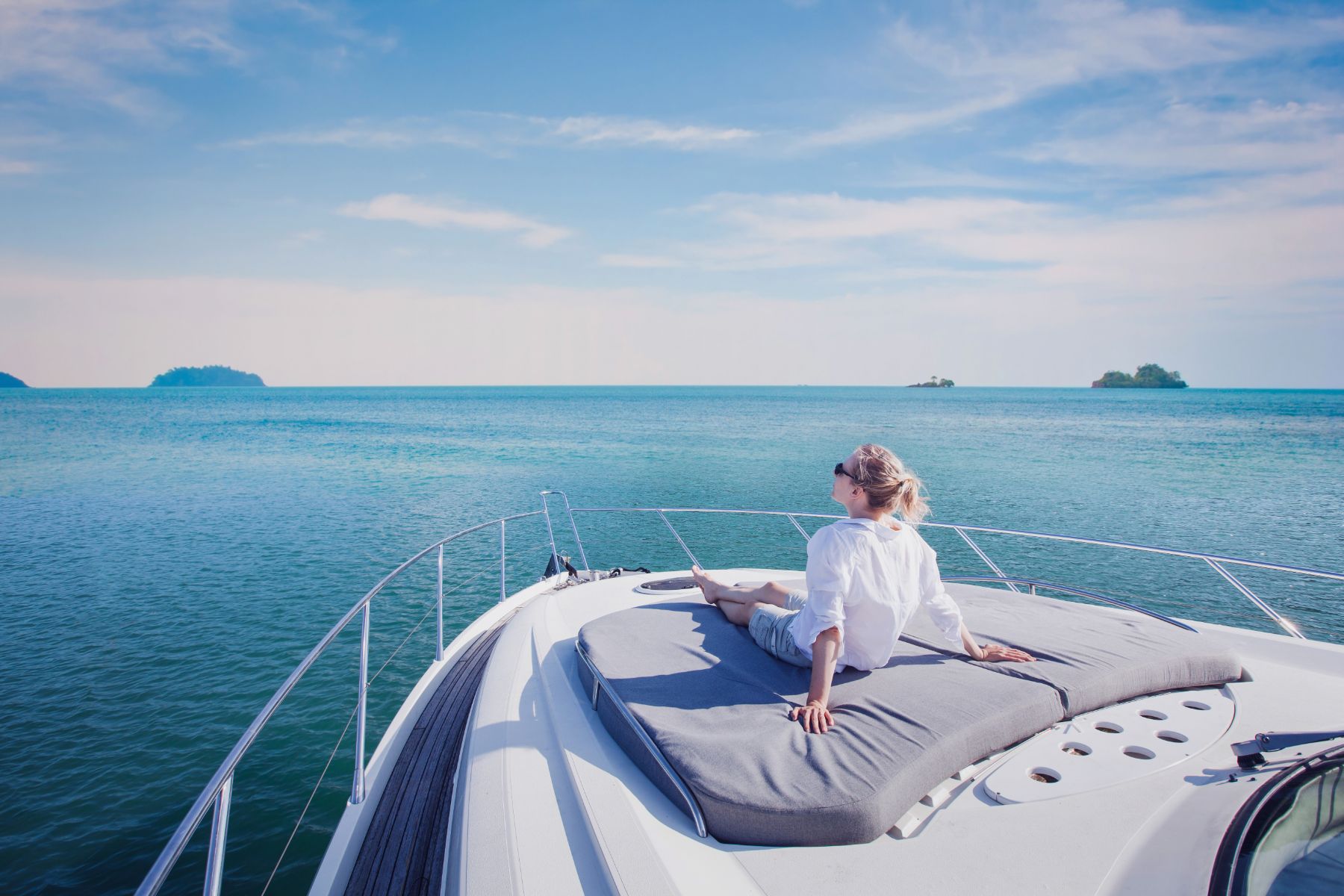 Lady relaxing on the sun deck of a yacht looking out to sea