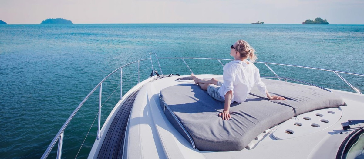 Lady relaxing on the sun deck of a yacht looking out to sea
