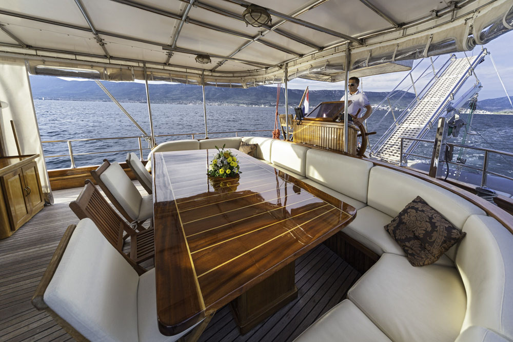 Outdoor dining area and captain aboard the Libra gulet in Croatia
