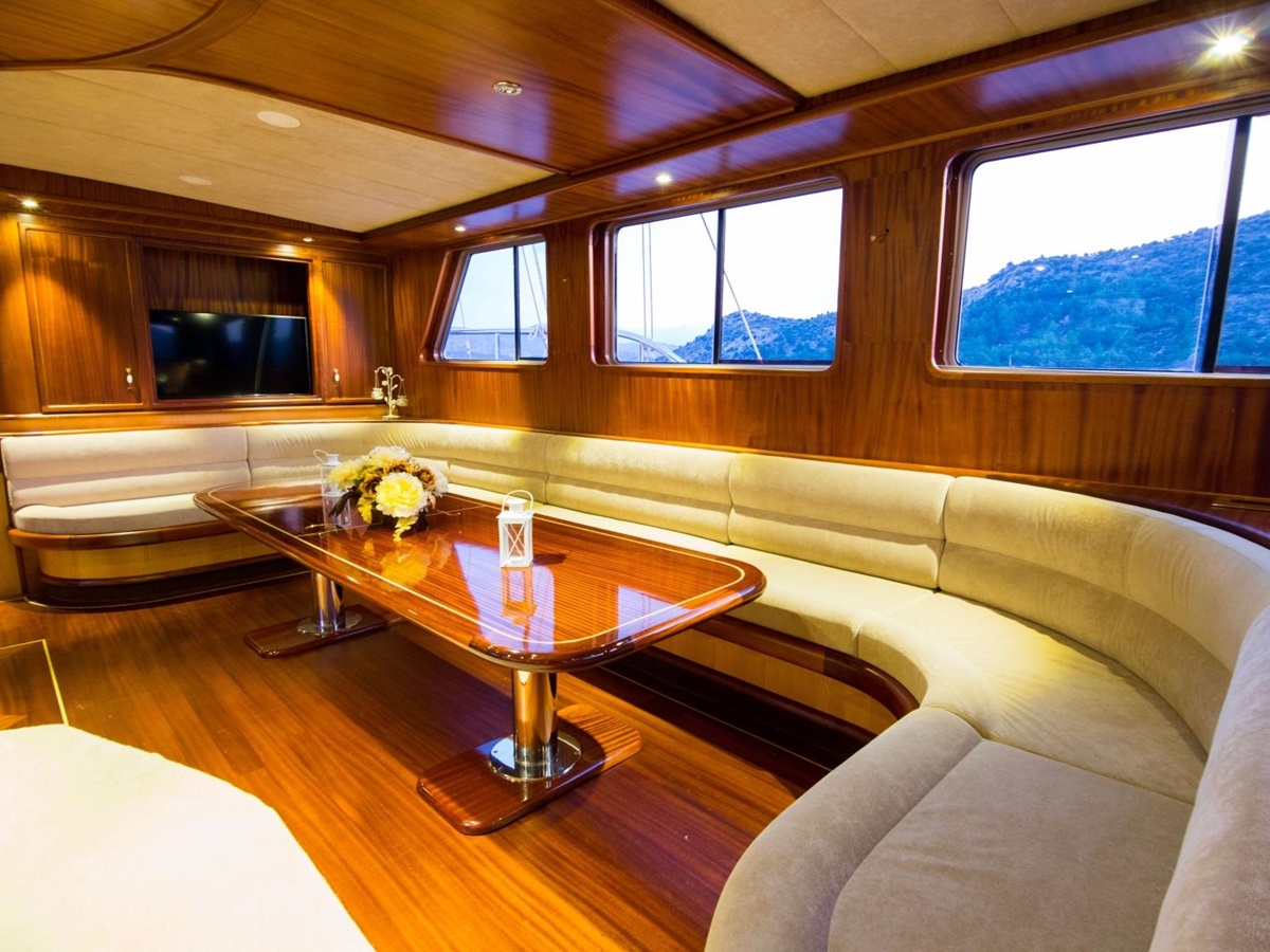Salon with dining area, flatscreen TV and panoramic views onboard the luxury gulet Nevra Queen