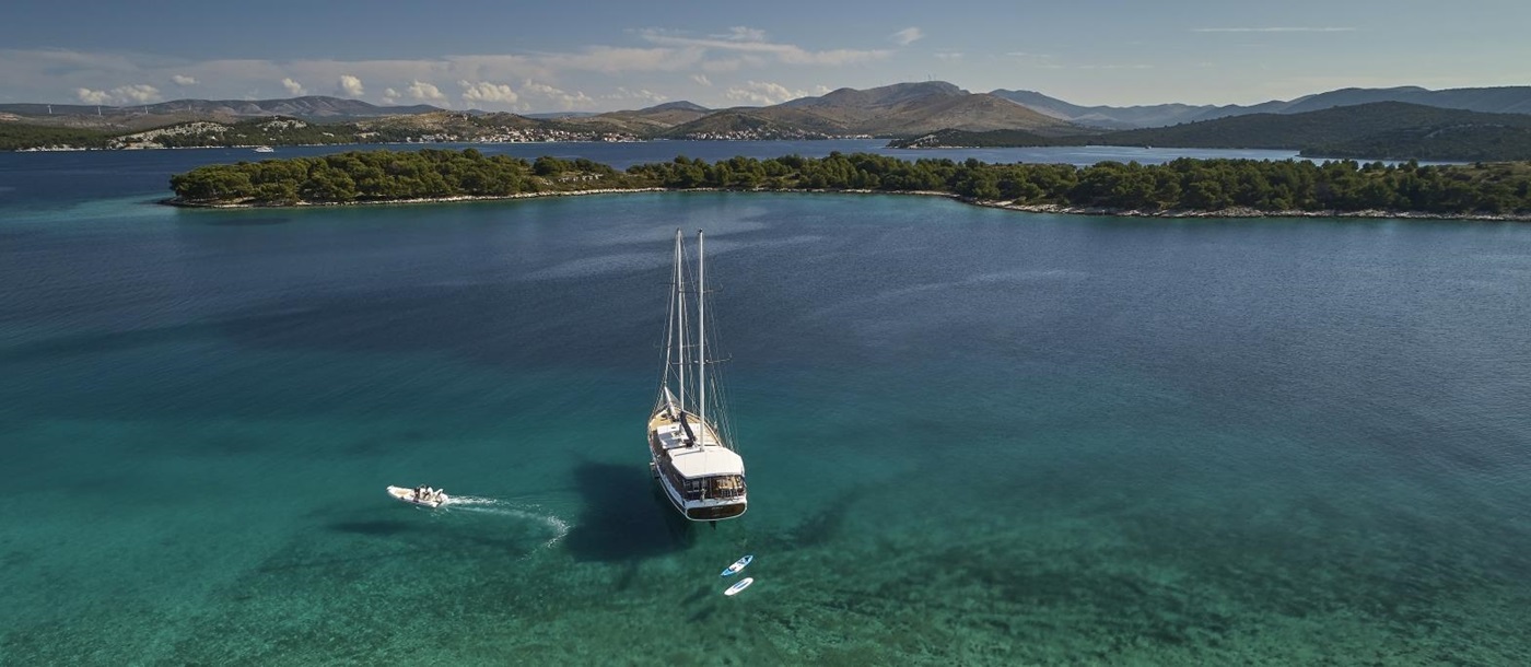 the luxury gulet Perla sailing along the Croatian coast with speedboat and paddleboard