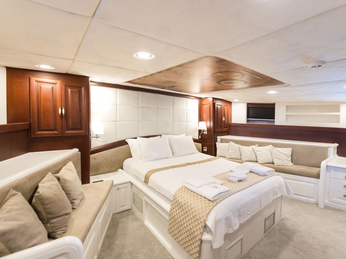 Spacious double cabin with windows, seating and plenty of storage onboard the luxury gulet Virtuoso