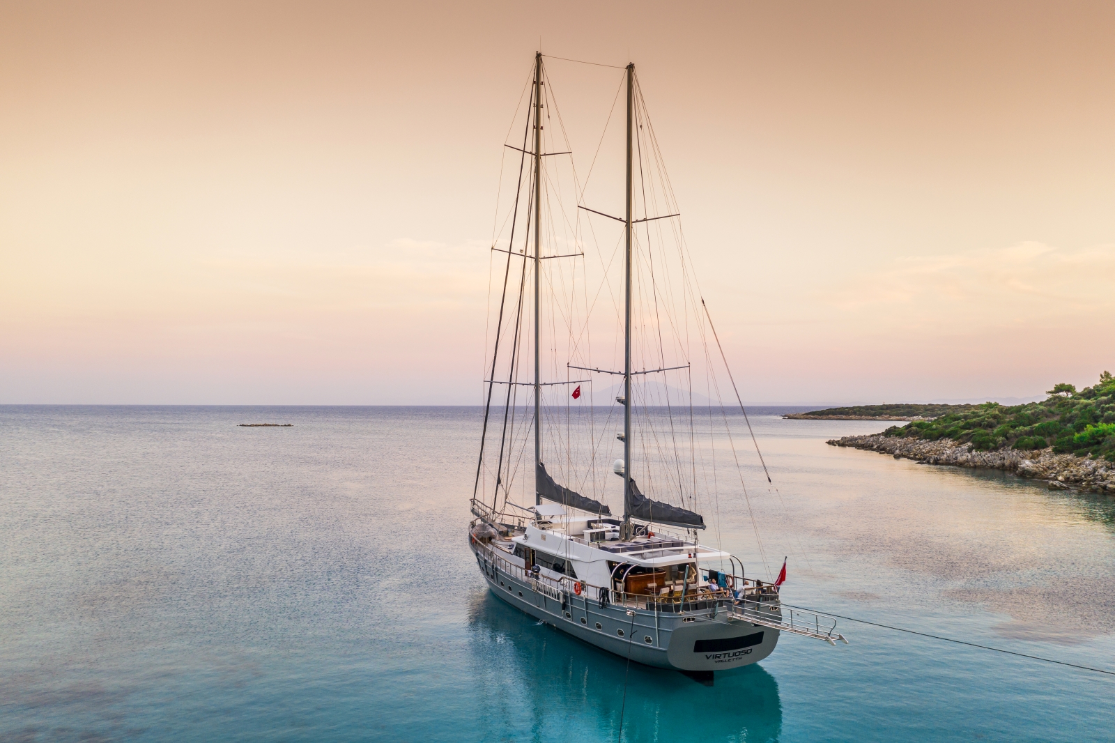 the luxury gulet Virtuoso sailing into the sunset on the turquoise waters of the Mediterranean Sea