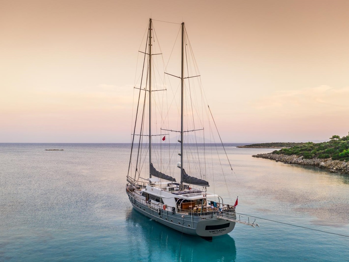 the luxury gulet Virtuoso sailing into the sunset on the turquoise waters of the Mediterranean Sea