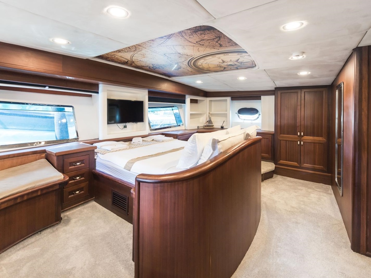 Master bedroom onboard the the luxury gulet Virtuoso with big windows, a flat screen tv and plenty of storage