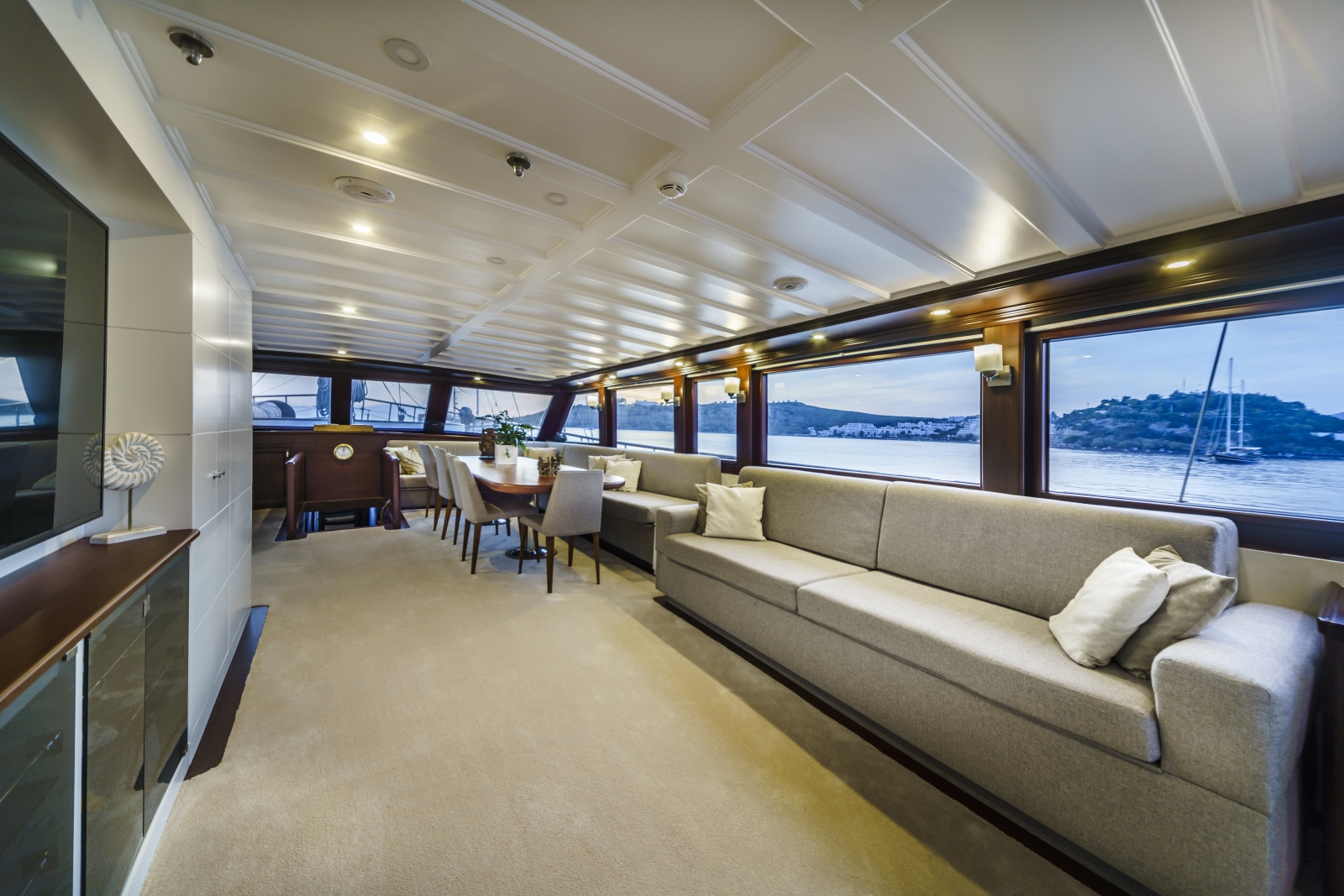 Salon of the luxury gulet Virtuoso, with comfortable lounge area, equipped with flat screen tv, and spacious dining area with panoramic views