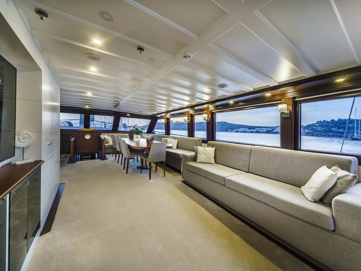 Salon of the luxury gulet Virtuoso, with comfortable lounge area, equipped with flat screen tv, and spacious dining area with panoramic views